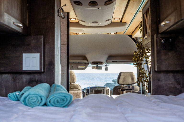 Camper Van Bed with Towels Looking at Water